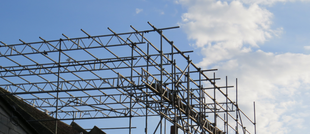 Scaffolding over the roof of a building covers part of the sky